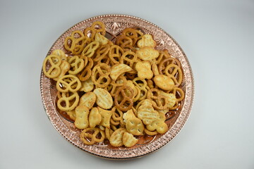 Mix of salty snacks (crackers and pretzels,bagels) in a bowl