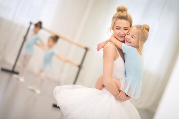Fototapeta premium laughing mom and daughter in ballet lessons