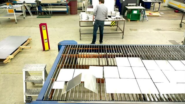 Edelstahl Metallverarbeitung - Laserschneiden - Anlage - Handwerker im Betrieb - Industrie Metallbau