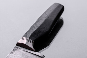 A large handmade hunting knife lying on a dark background