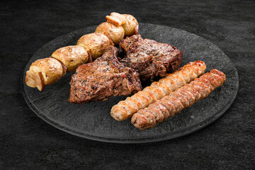 A selection of grilled gourmet meats on a rustic stone board.  Assorted meat