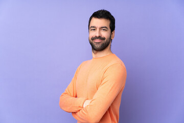 Caucasian handsome man over isolated purple background with arms crossed and looking forward