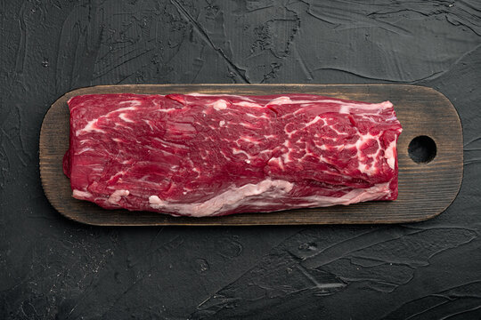 Raw beef meat , on wooden cutting board, on black stone background, Filet mignon cut, top view flat lay