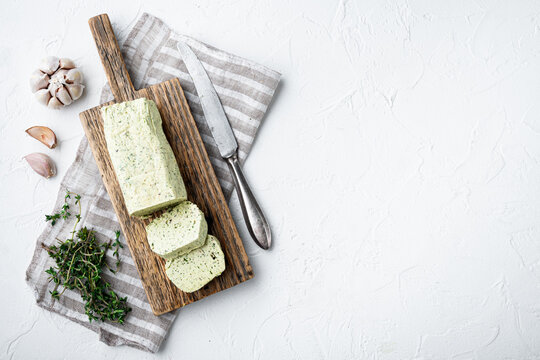 Dairy green butter with herbs, on white stone  background, with copy space for text