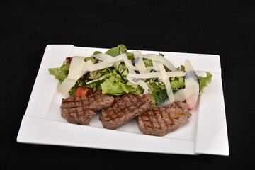 Grilling steaks  with salad and  Parmesan cheese