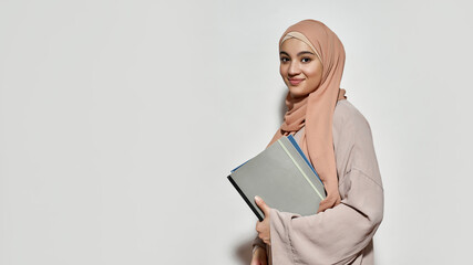 Happy young arabian woman in hijab with notepad