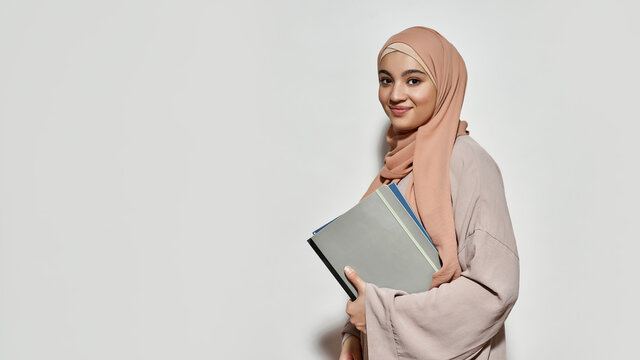 Happy young arabian woman in hijab with notepad