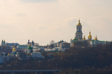Fototapeta premium Scenic spring view of famous Kyiv's hills against blue sky. Scenic landscape of ancient Kyiv Pechersk Lavra. It is a historic Orthodox Christian monastery. Kyiv, Ukraine