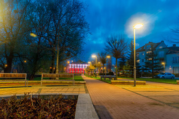 City centre of Pruszcz Gdanski with City hall of Pruszcz Gdanski in background. White and red illuminate of City hall of Pruszcz Gdanski at 3 May Constitution Day in 2021.
