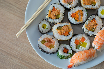 Closeup on sushi set of maki with chopsticks on a white plate