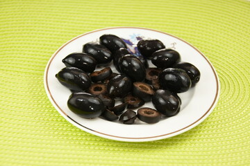 black olives on a  porcelain plate 