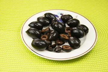 black olives on a  porcelain plate 