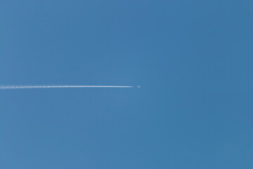 Airplane fly in blue sky with condensation trail. Track from the plane in the sky.