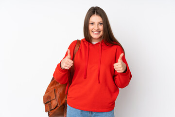 Teenager caucasian student girl isolated on white background giving a thumbs up gesture