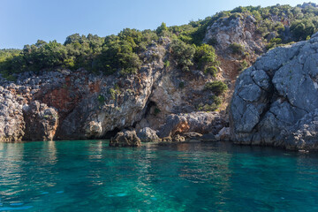 Amazing turquoise clear sea and rocks surrounded by vegetation, Albania. Travel and vacation theme