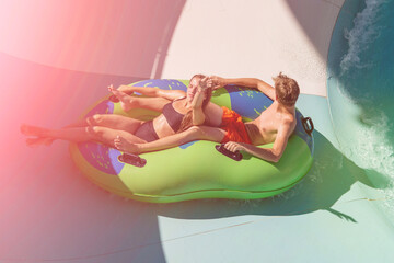 Girl and boy in water Park. Fun on the water. Teen girl and boy having fun in the water slider . Happy children's vacation outdoor.