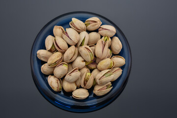 Roasted pistachio seeds on a blue plate