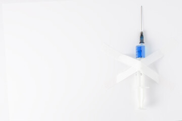 plastic medical syringe with white tape on a white background. concept of refusing vaccinations
