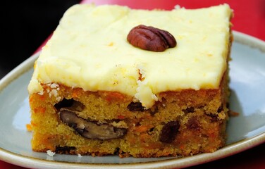 Dairy free carrot and pecan cake with icing made with carrot, rapeseed oil, caster sugar, self raising flour, sultanas, pecans and eggs in Bath, England, UK