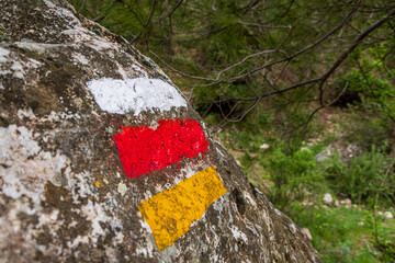 Colored markings painted on a rock, to mark the way for walkers and nature walkers.