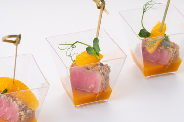 tuna, sesame and orange slices canapes on a white background. Catering services
