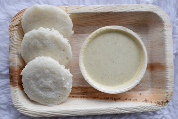 Delicious South indian popular breakfast Idli with white chutney served in plate.