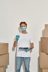 Vertical photo of a young deliveryman filling in working blanks 