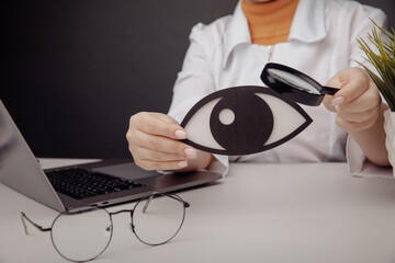 Doctor showing a wooden eye by magnifier. Healthcare concept