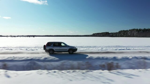 suv driving in remote winter road aerial low flight