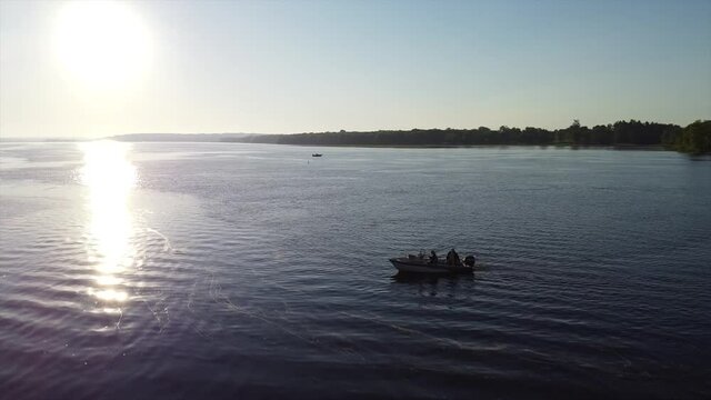 two men in fishing boat sunny aerial fly by.
