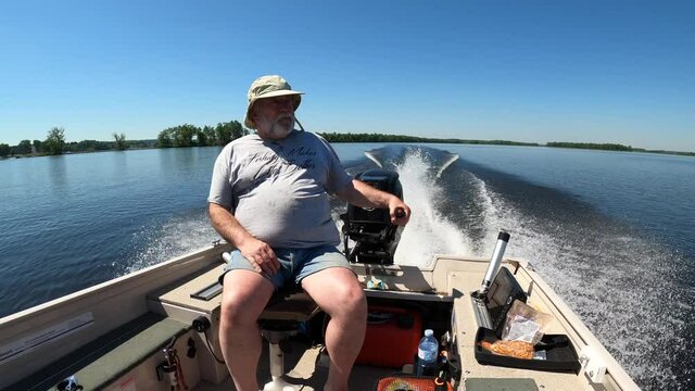 old man driving fishing boat slow motion sunny day
