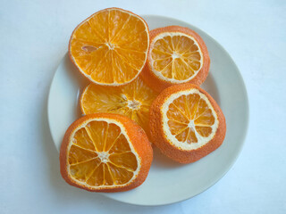 dried orange slices on a white saucer on a light background