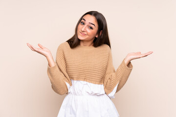 Young caucasian woman isolated on beige background having doubts while raising hands