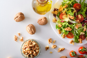 Mediterranean salad with walnuts in plate with olive oil top