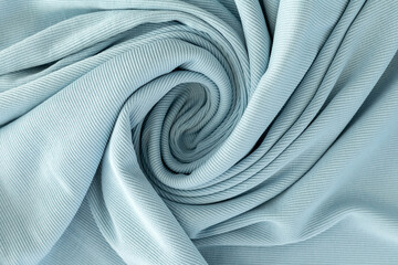 soft knitted fabric for sewing clothes in turquoise color, coiled
