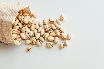 Pile of pistachios on the light background. Pistachio is a healthy vegetarian protein nutritious food. Vegetarian food concept.