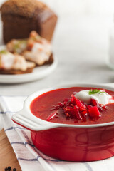 Delicious fresh red borscht, dark bread with lard and salt n kitchen table. 