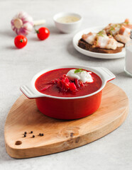 Delicious fresh red borscht, dark bread with lard and salt n kitchen table. 