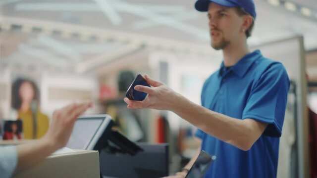 Clothing Store Checkout Cashier Counter: Handsome Courier Takes Package to Deliver for Online Order. Fashion Shop with of Designer Brands Available for Online Shopping and Purchase. Slow Motion