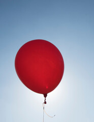 red balloon and blue sky background with sun