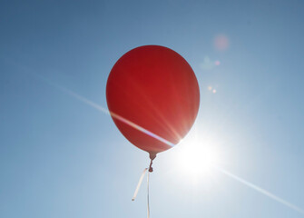 red balloon and blue sky background with sun