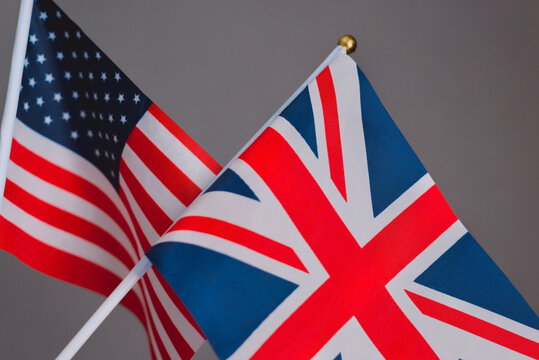 Flags of the United Kingdom and the United States isolated on a grey background.