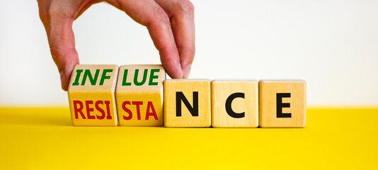 Influence or resistance symbol. Businessman turns cubes, changes the word 'resistance' to 'influence'. Beautiful white background. Copy space. Business and influence or resistance concept.