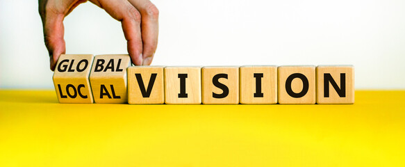 From local to global vision. Businessman turns cubes and changes words 'local vision' to 'global...