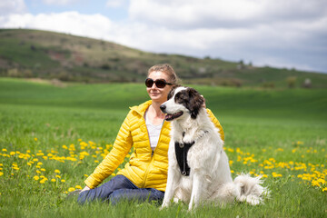 woman with dog relaxing in green spring landscape