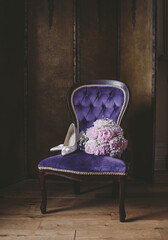 Bridal shoes with rose bouquet on purple velvet chair, vintage