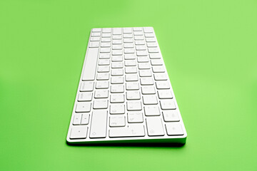 White wireless computer keyboard isolated on green background. Russian / English keyboard layout