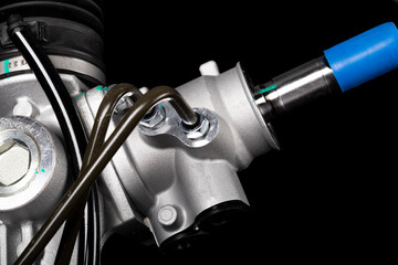 Studio lighting. on a black background, the steering rack of the car. New part.