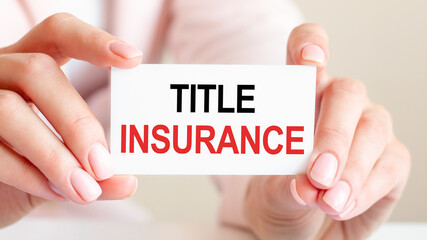 title insurance written on a card in woman hands, concept