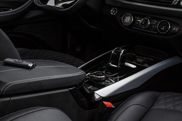 Obraz na płótnie Canvas Black interior of a modern car. Focused on hift lever and dashboard. Black leather interior.